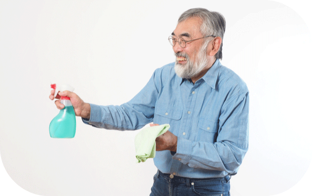 洗剤と雑巾を持って掃除しているじいじの写真