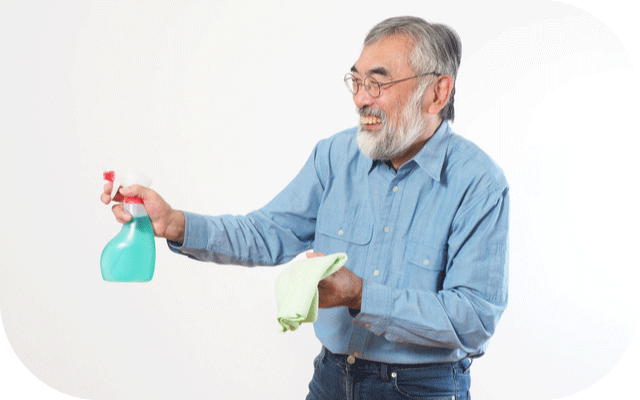 洗剤と雑巾を持って掃除しているじいじの写真