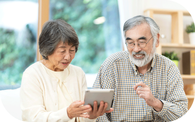 リビングでタブレットを使って暮らしぶりチェック項目を確認するじいじとばあばの様子