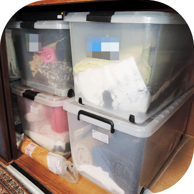 大きくて重たいプラスティック衣装ケースが押入れに隙間なく積み重ねられた様子