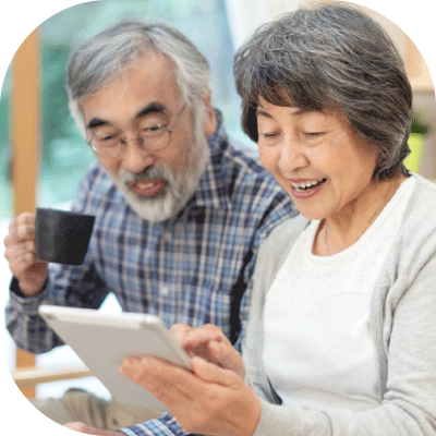 じいじとばあばがリビングでタブレットから問い合わせしている写真