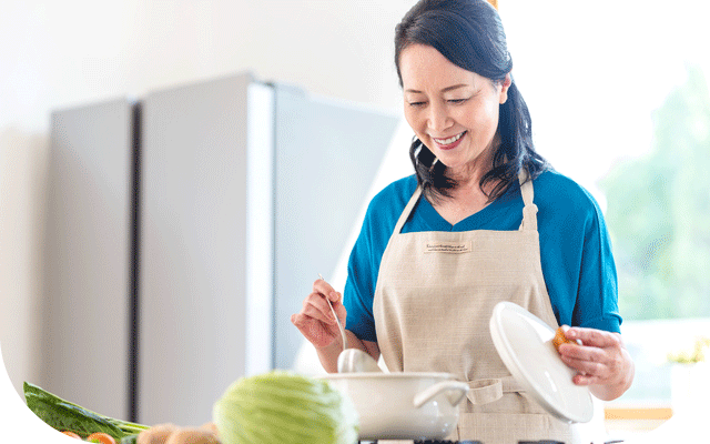 キッチンで料理するばあばの写真