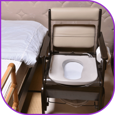 ベッドの横にポータブルトイレを置いた様子