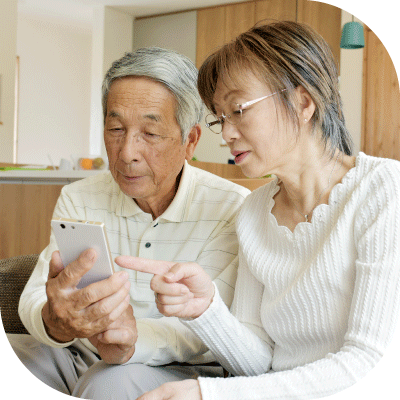 じいじとばあばがリビングでタブレットから問い合わせしている写真