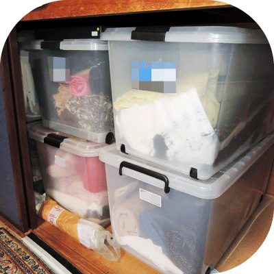 大きくて重たいプラスティック衣装ケースが押入れに隙間なく積み重ねられた様子